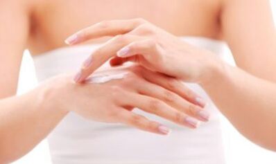 a girl applying ointment to her hand